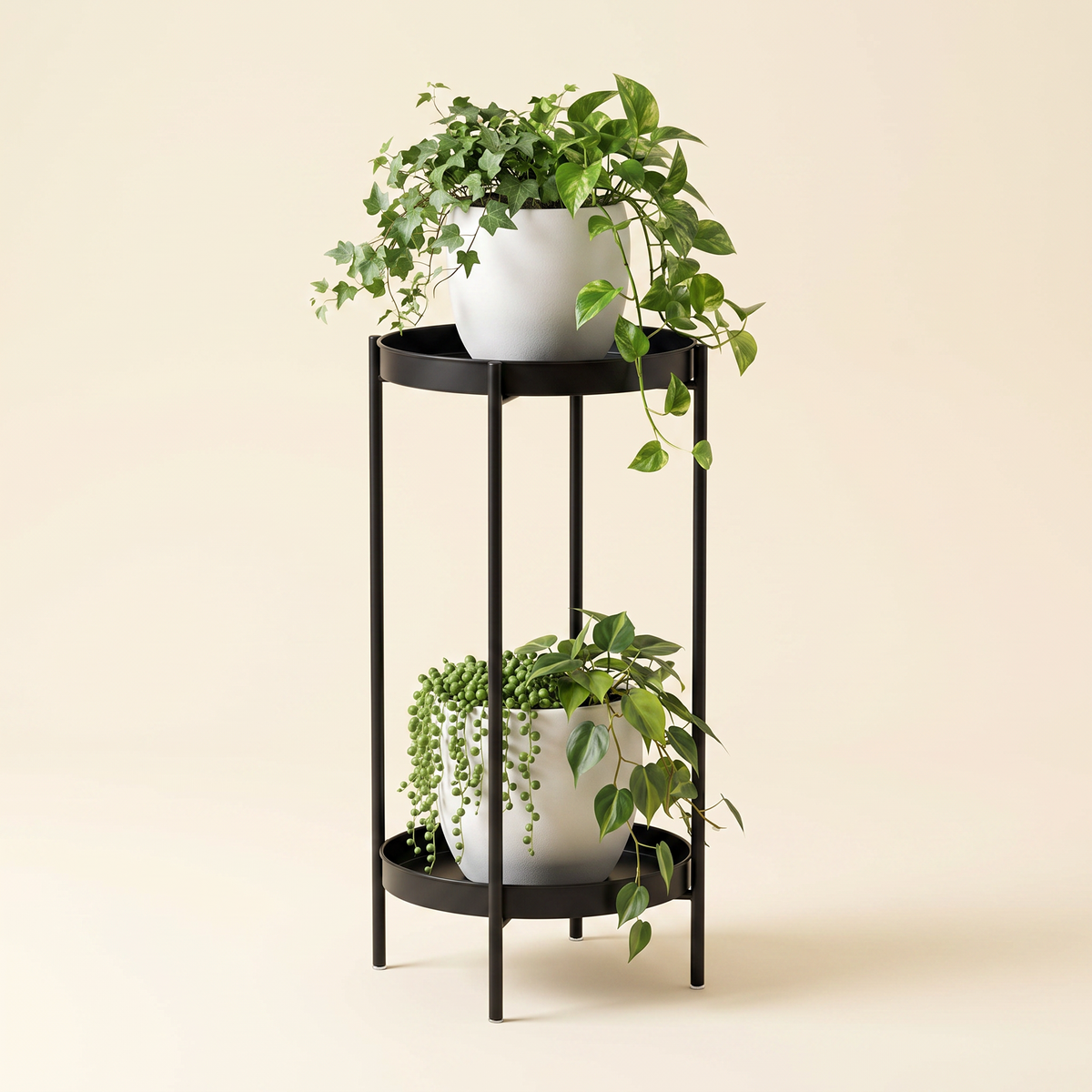 Modern 2-tier black metal plant stand with white ceramic pots and trailing plants, studio shot